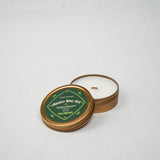 Candle in a tin with a green label on a white background