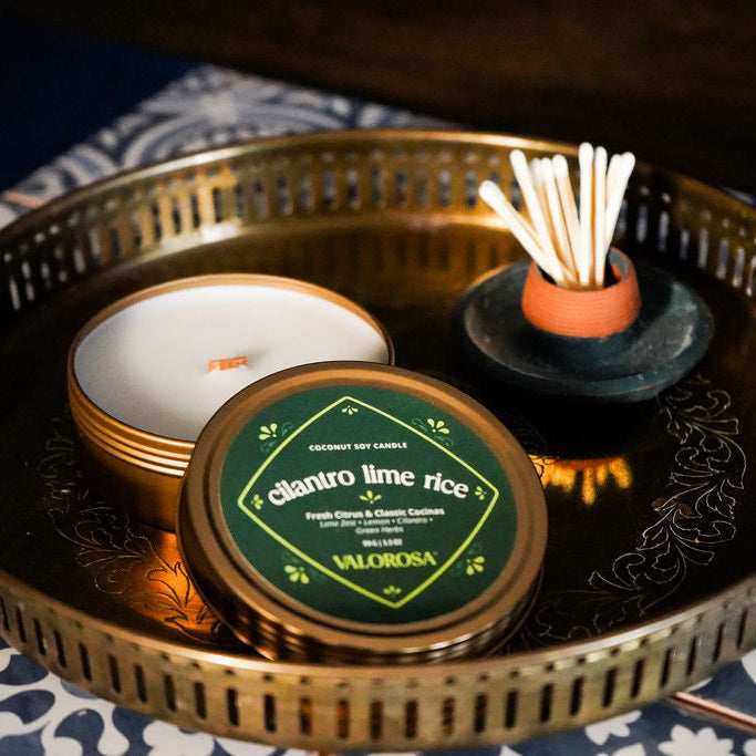 Candle with lid, matches, and decorative tray on a patterned surface