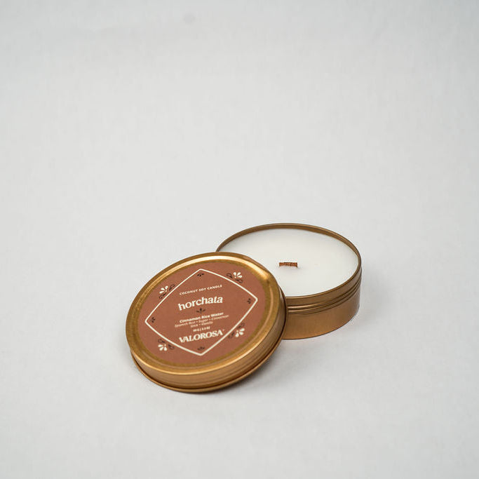 Small round horchata candle tin with a lid on a white background
