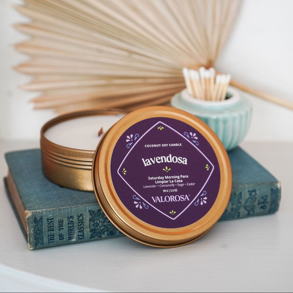 Lavendosa Candle Tin with 'Valorosa' branding on a white surface with dried plants and books.