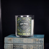 Valorosa Candle labeled 'Agua Fresca' on a stack of books with a dark background