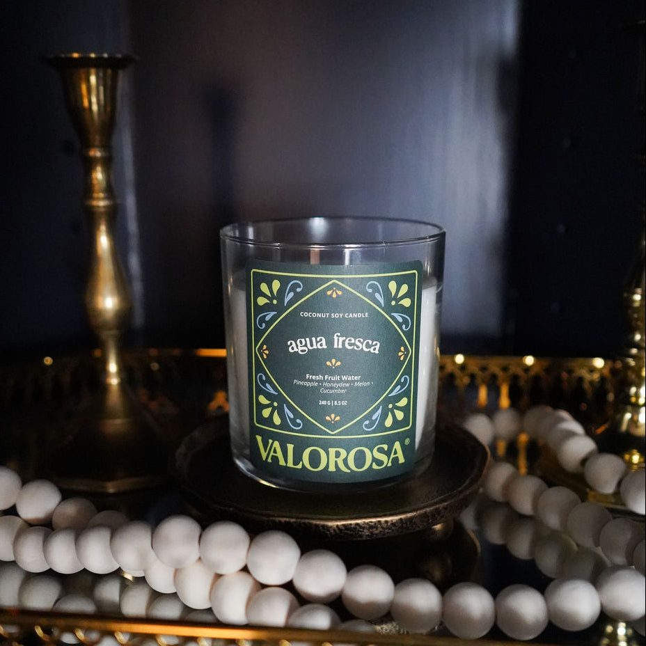 Valorosa Agua Fresca Candle on a decorative table with a dark background