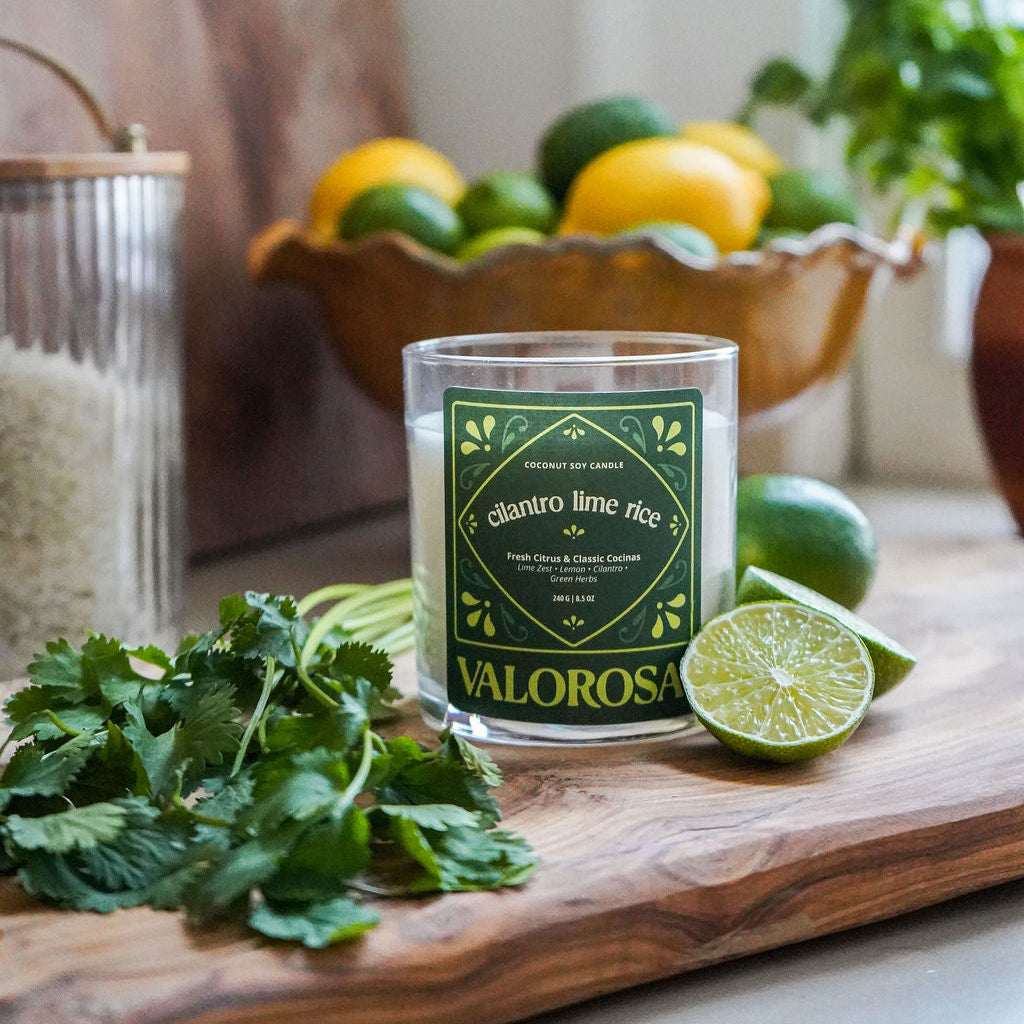 Valorosa candle on a wooden cutting board with limes and cilantro